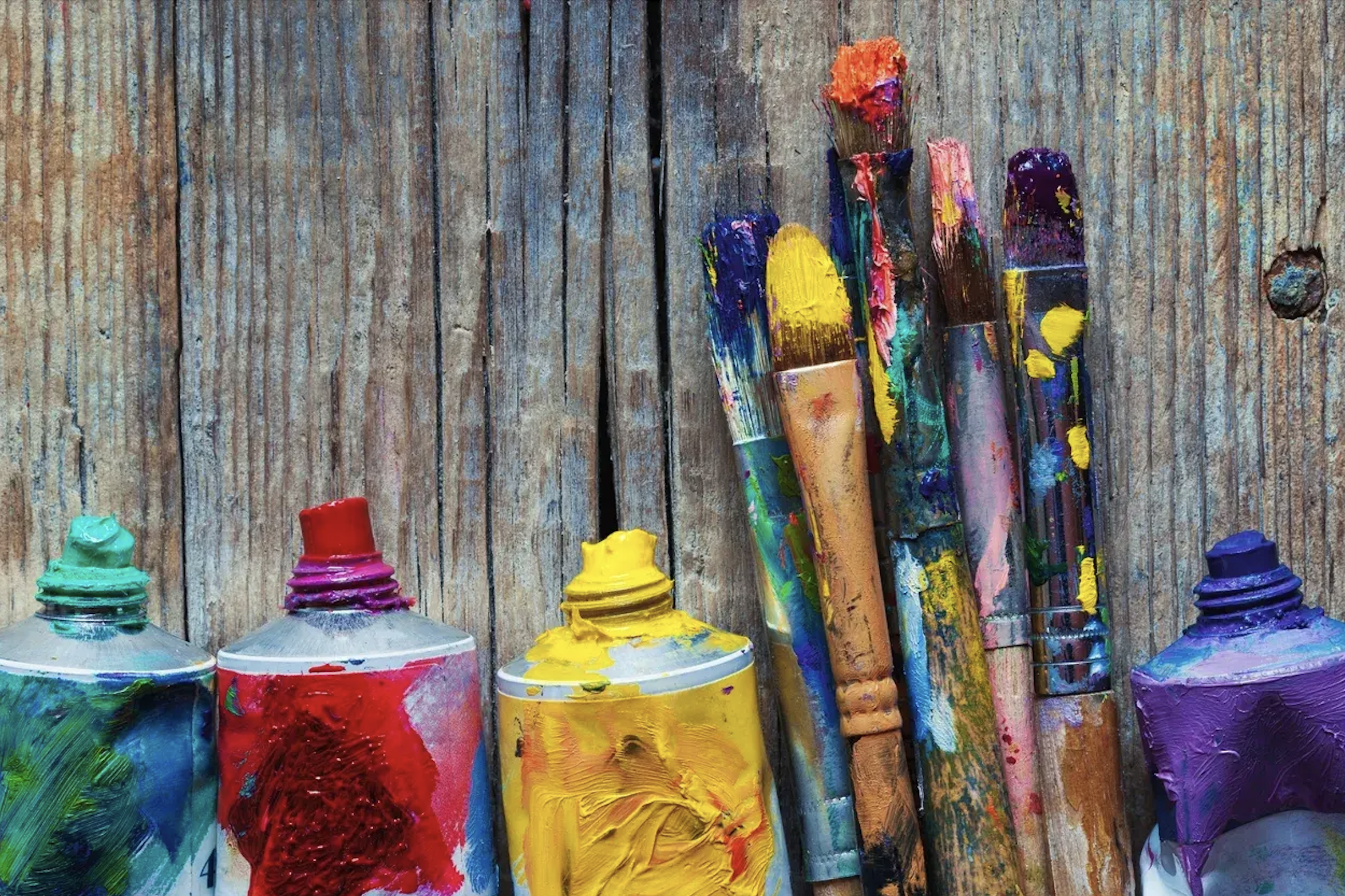 paint tubes and brushes on wooden table