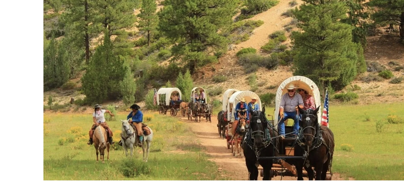 Students and teachers riding horses and in cover wagons