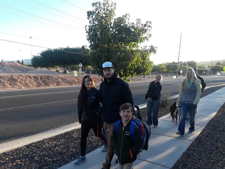 parent and student walking on sidewalk