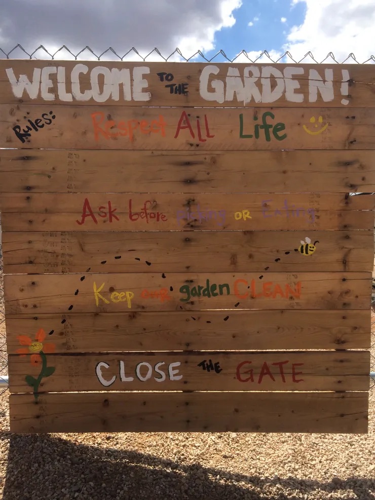 Welcome to the Garden" sign with colorful text.