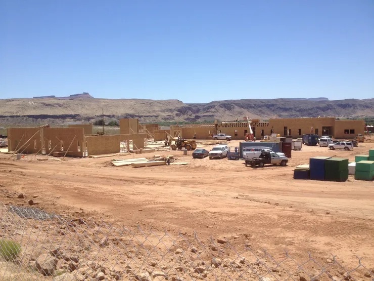 Under construction: a small building site with a few tools and materials visible, set against a clear sky and arid landscape.