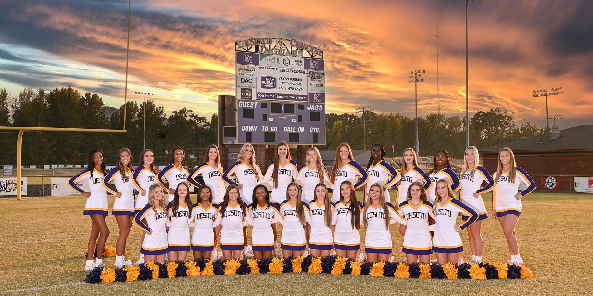 Cheer Team posed in uniforms on the football field