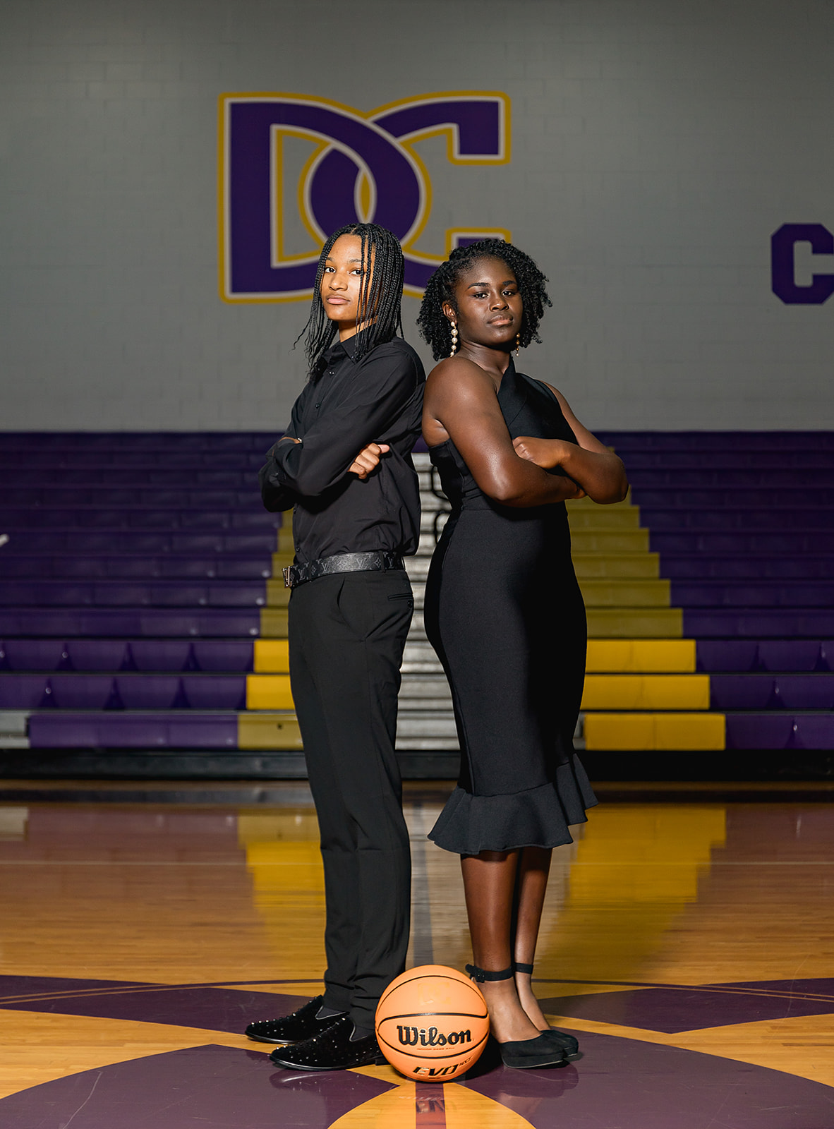 Two Lady Jags team members standing back to back on the basketball court