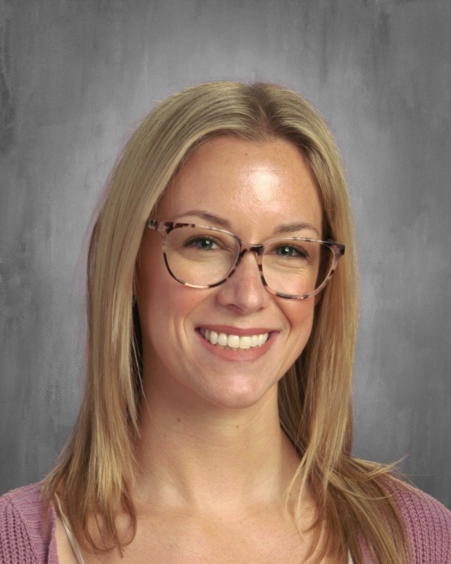 A Headshot of Ashley Rhodes the Assistant Principal Smiling at the Camera in her Glasses 