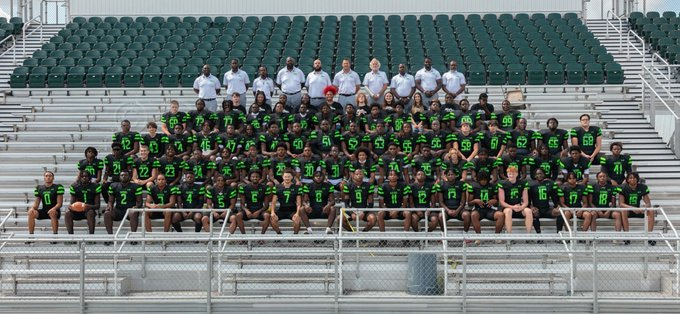 Football team and coaches sitting on bleachers