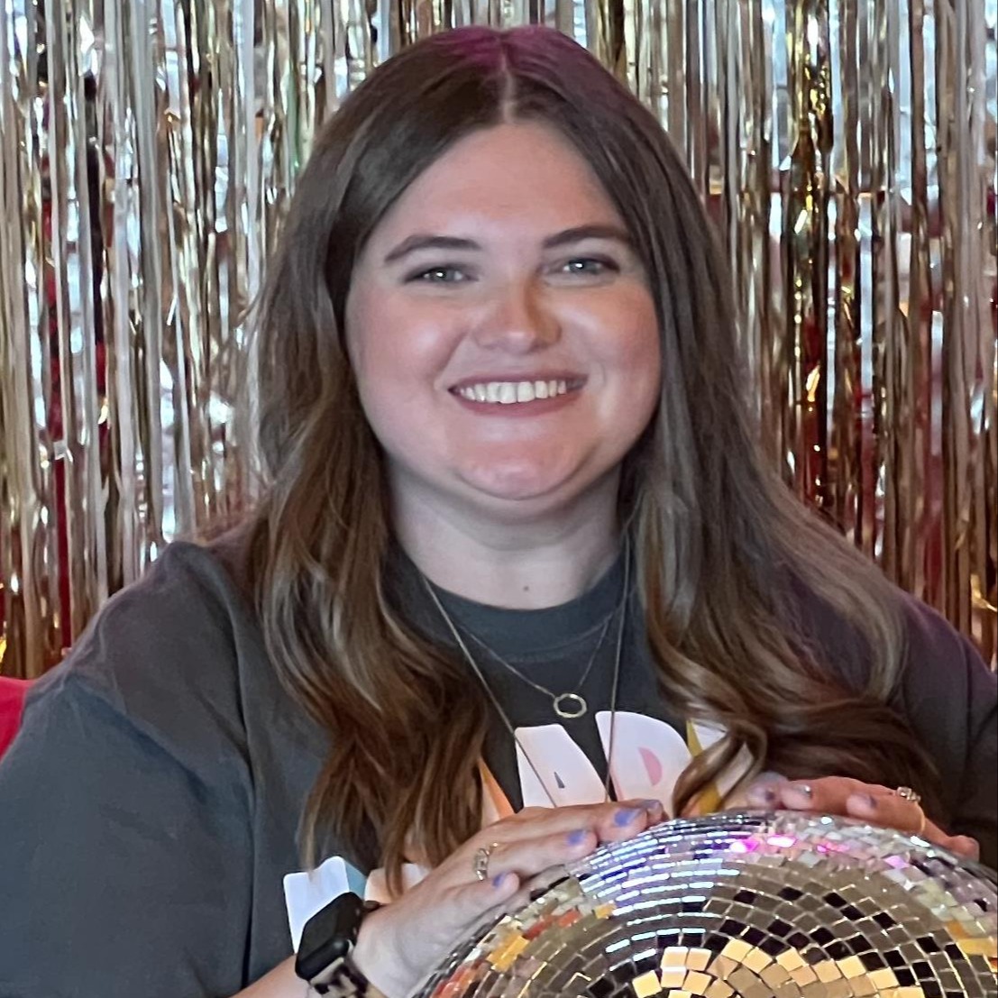 Mrs. Booher 3rd and 4th grade counselor smiling holding disco ball