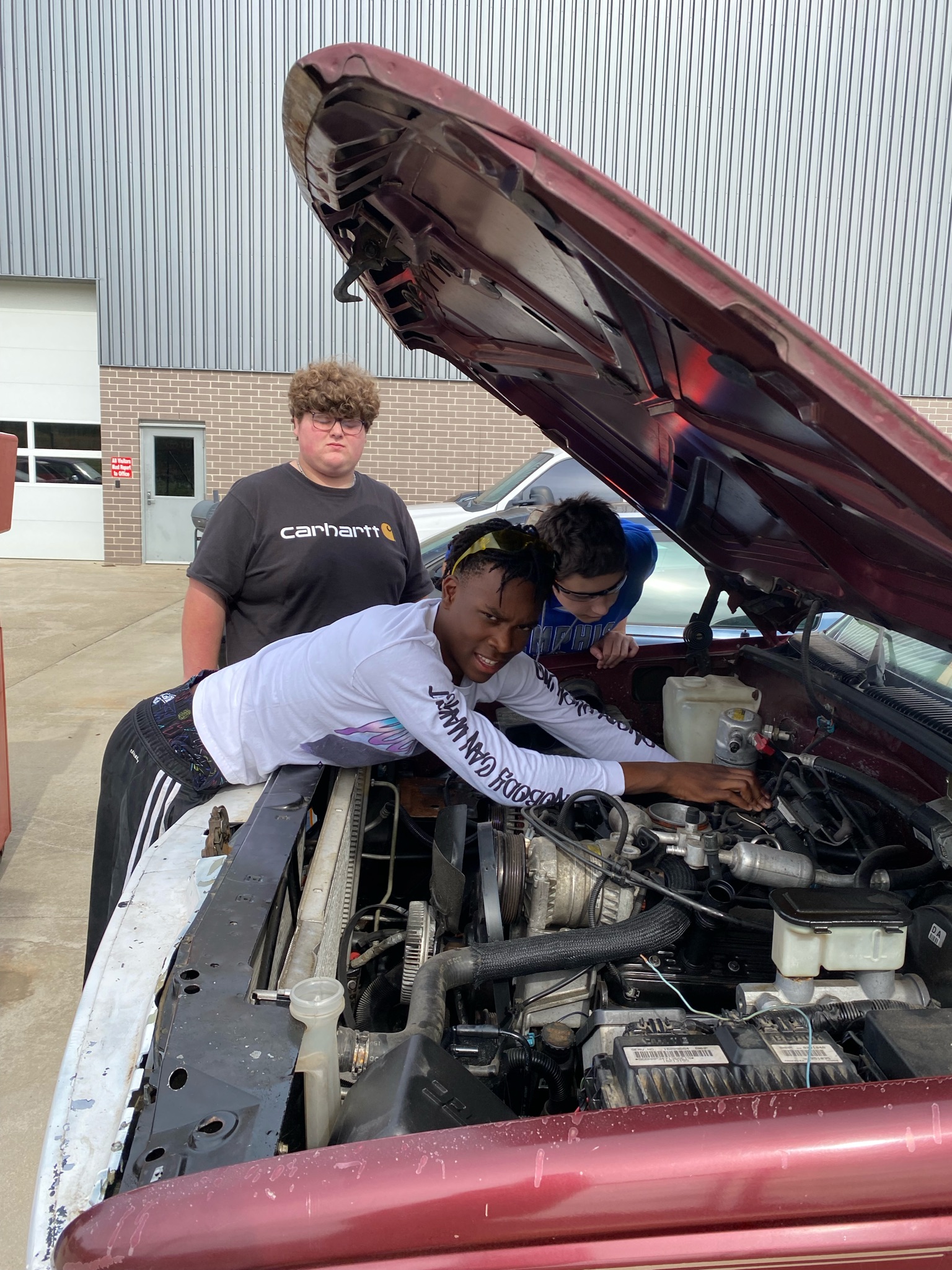 Students working on a truck with the hood open