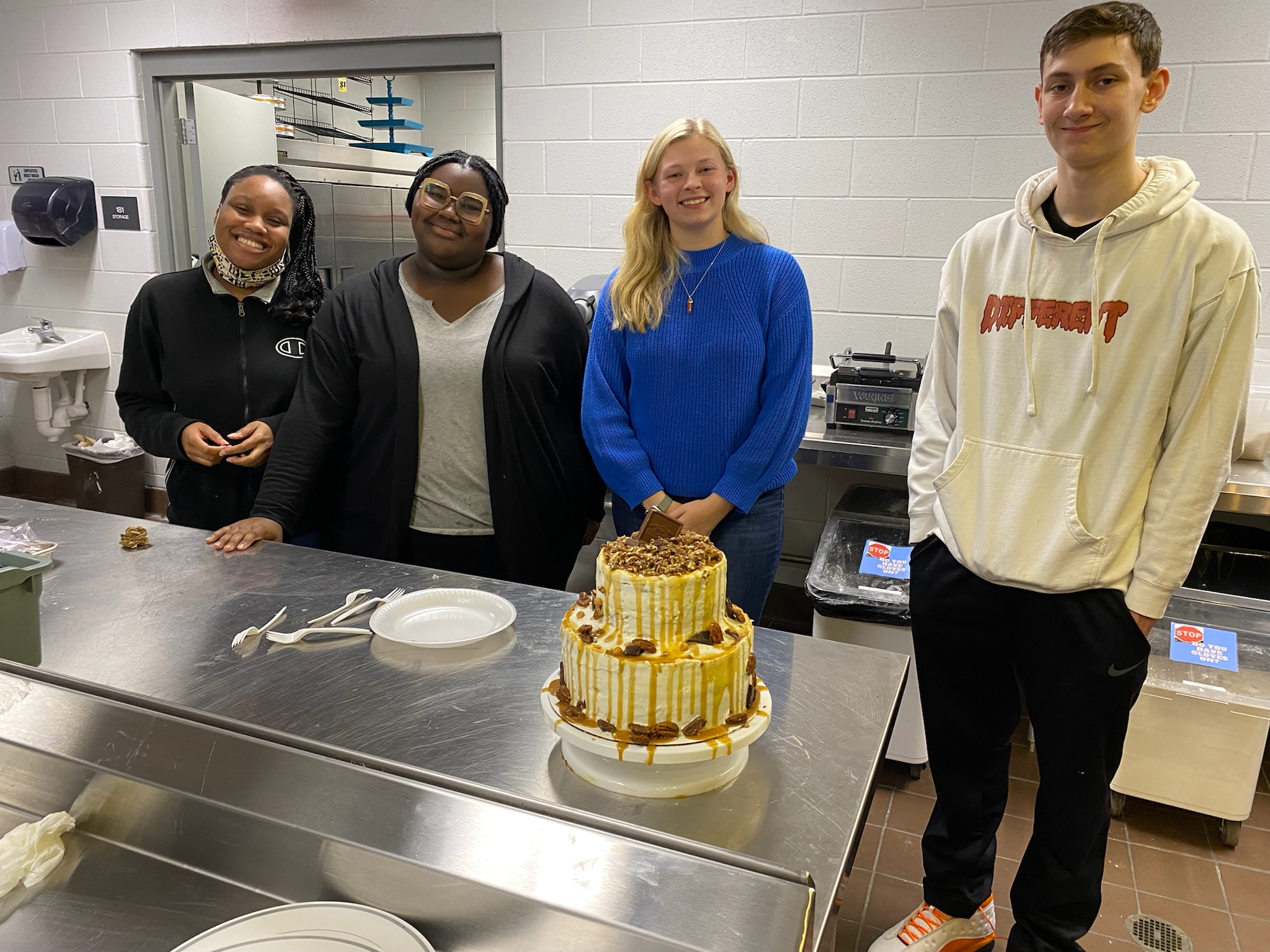 Students standing by a cake