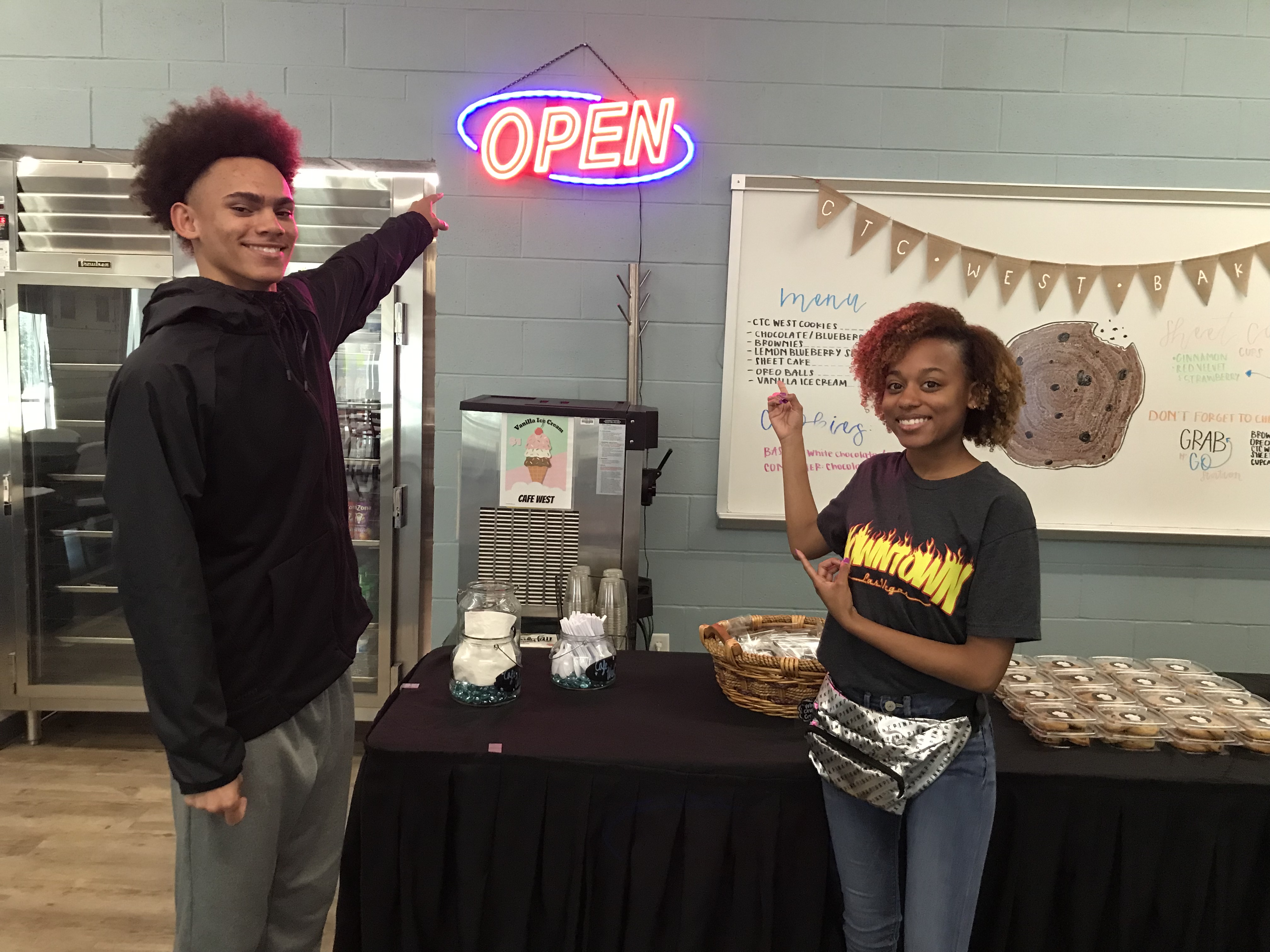 Student pointing at an OPEN sign
