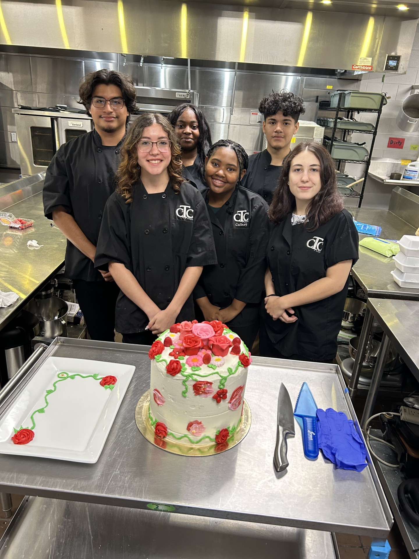 Students standing by a cake