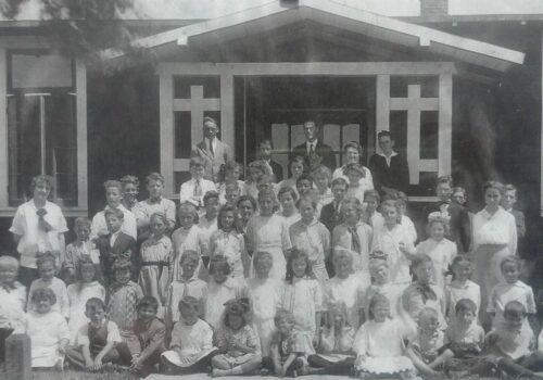 students in front of old school