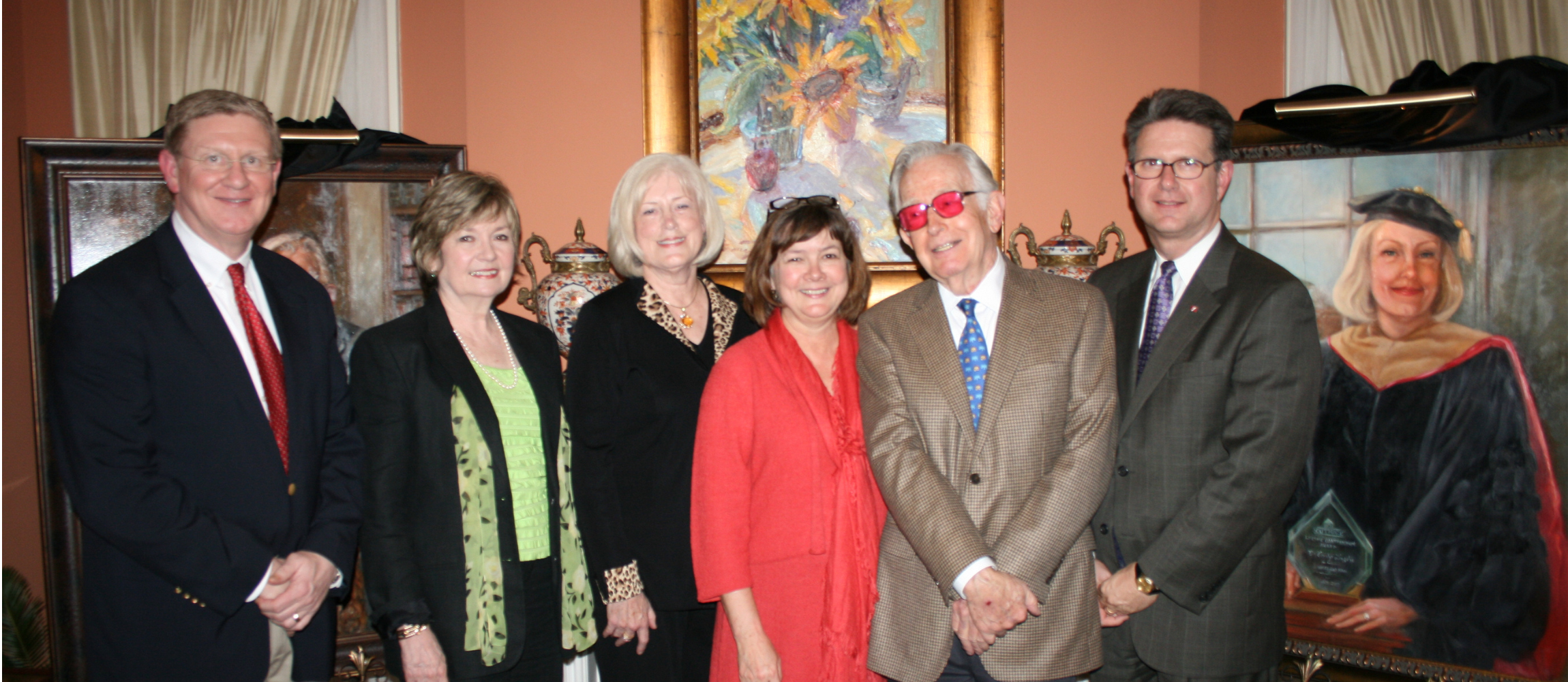 Group photo of SouthArk employees in between the two portraits being unveiled of Dr. Carolyn Langston and Charlie Thomas