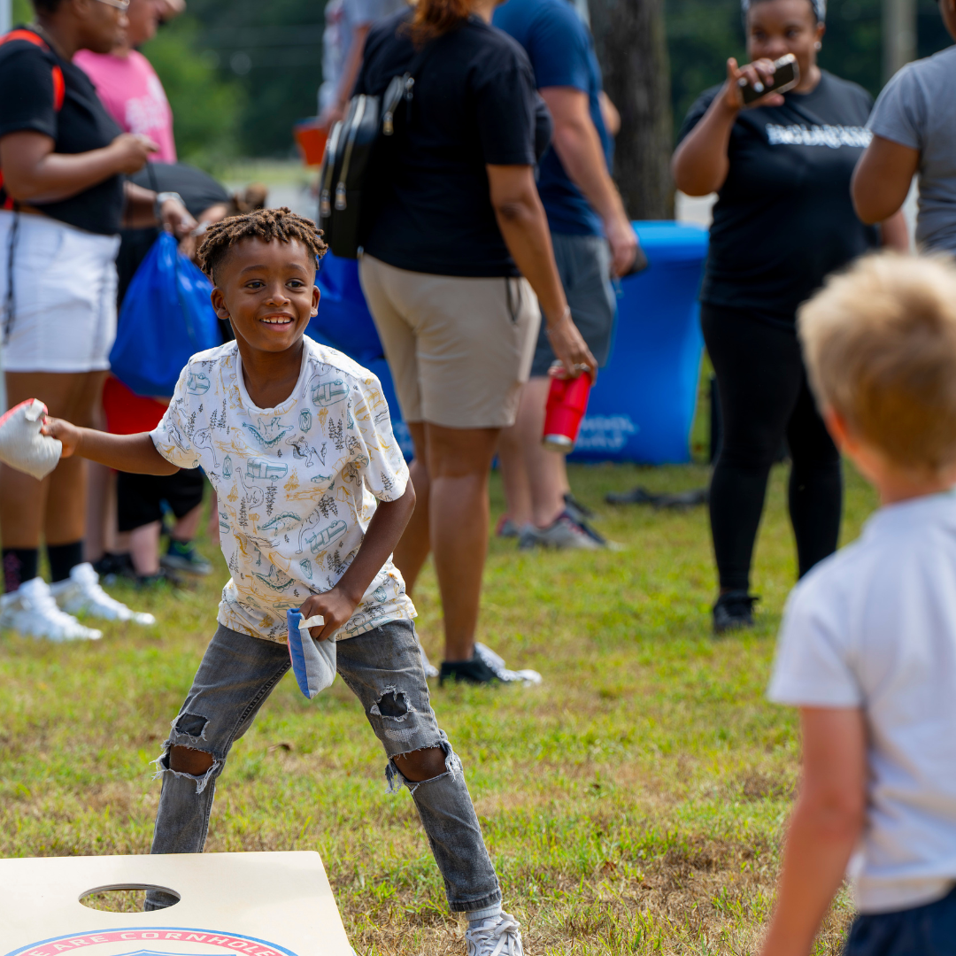 Photo of two children playing cornhole at the 2024 Outdoor Expo Kids World