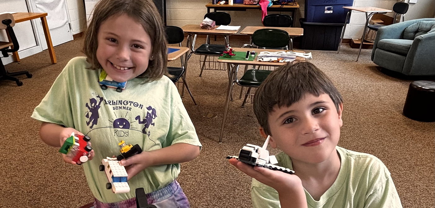 A girl and a boy holding their Lego creations