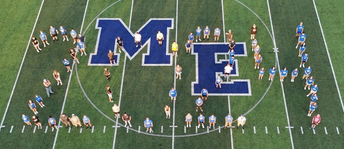 Senior class standing on the football field in the shape of 2024.