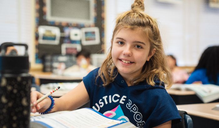 Elementary-aged girl smiling in the classroom