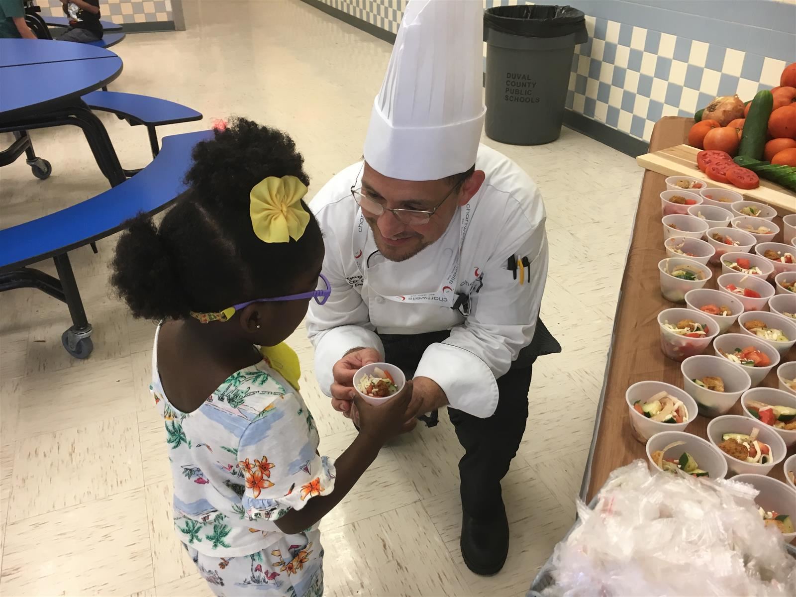 Chef offering food to a child