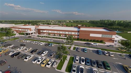 The image shows a modern building, likely an educational institution, with a clear view of the entrance and parking lot.