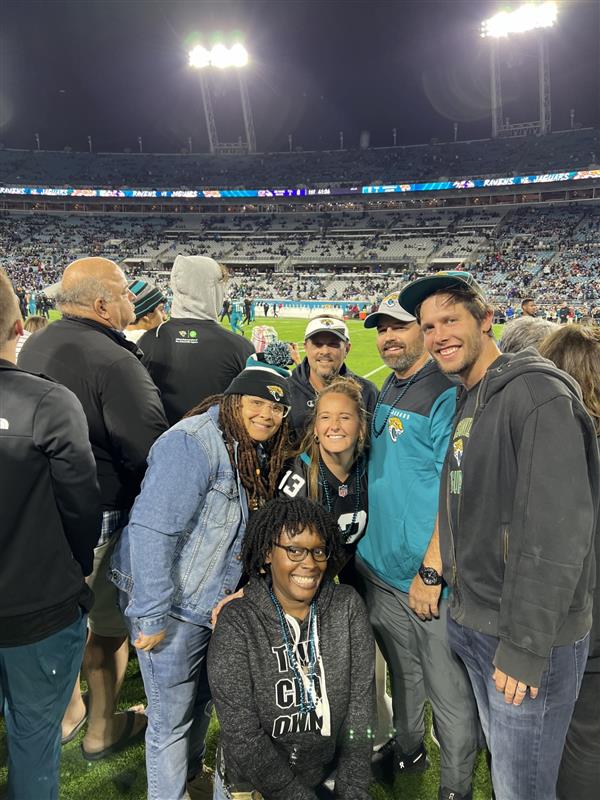 people smiling in the seats of a stadium 