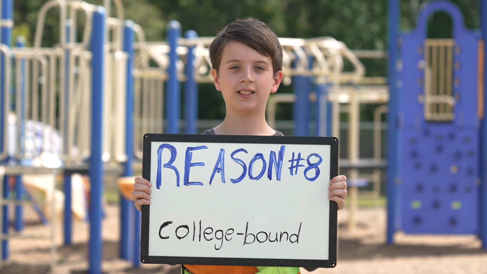 Boy holding a sign that states "Reason #8, College-bound"