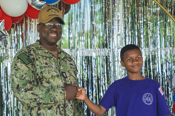 Military person fist bump a student