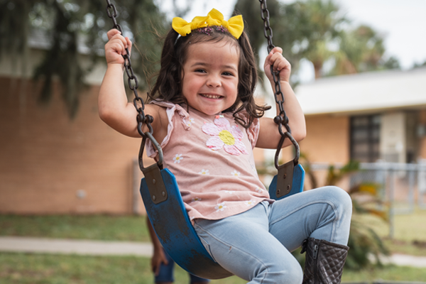 A Pre-Kindergarten girl playing in a swing