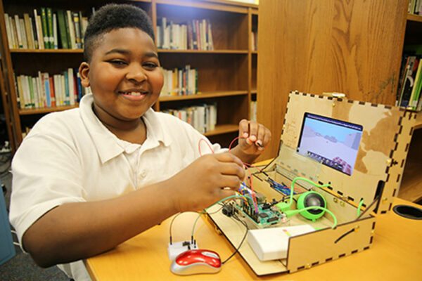 Student smiling while working on STEM project