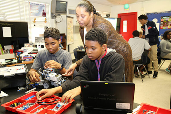 Teacher helping students with their project