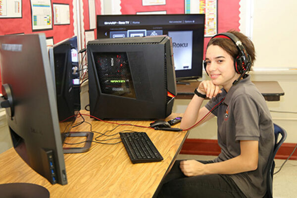 Student smiling while looking at the computer