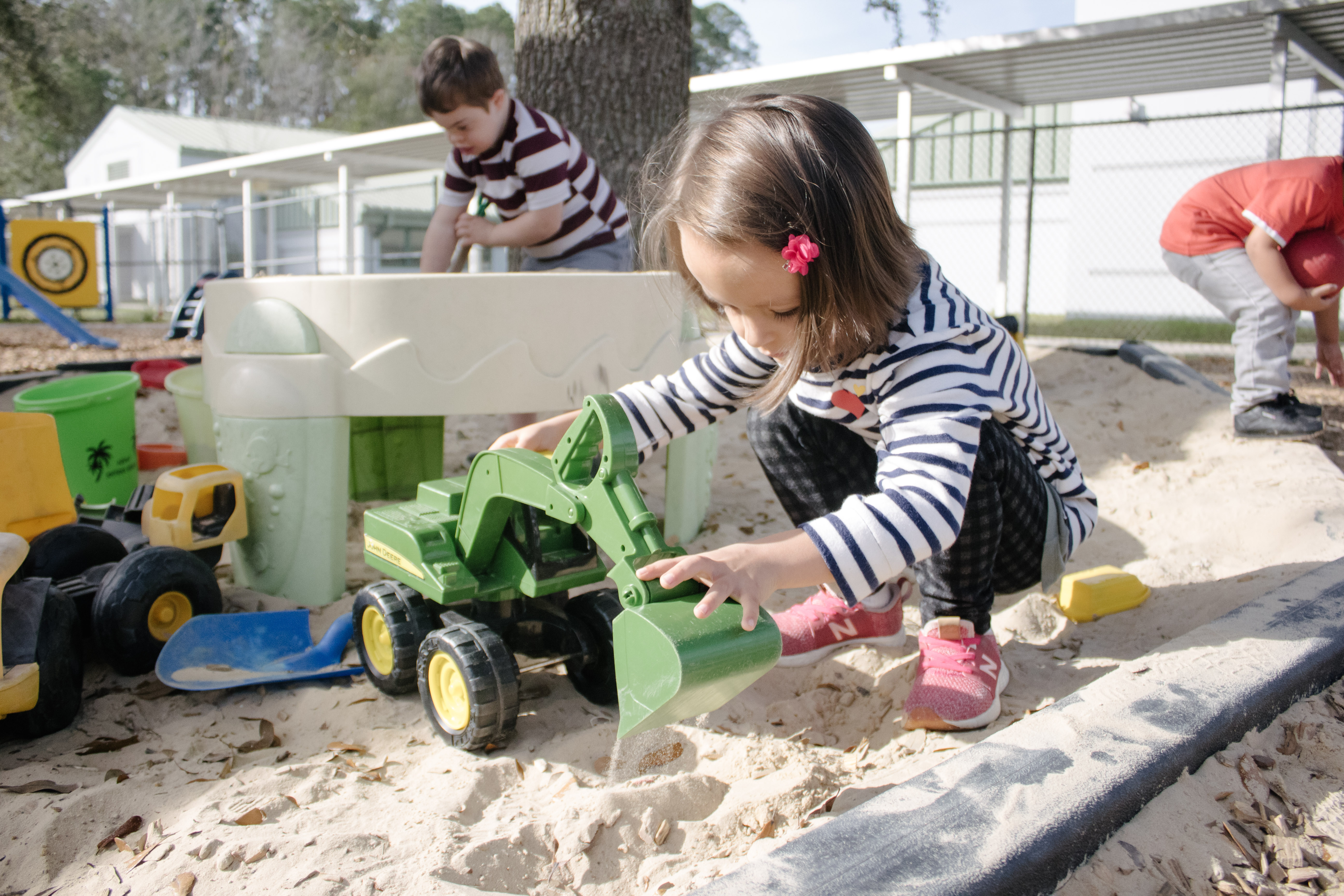 VPK student playing with a toy truck on playground