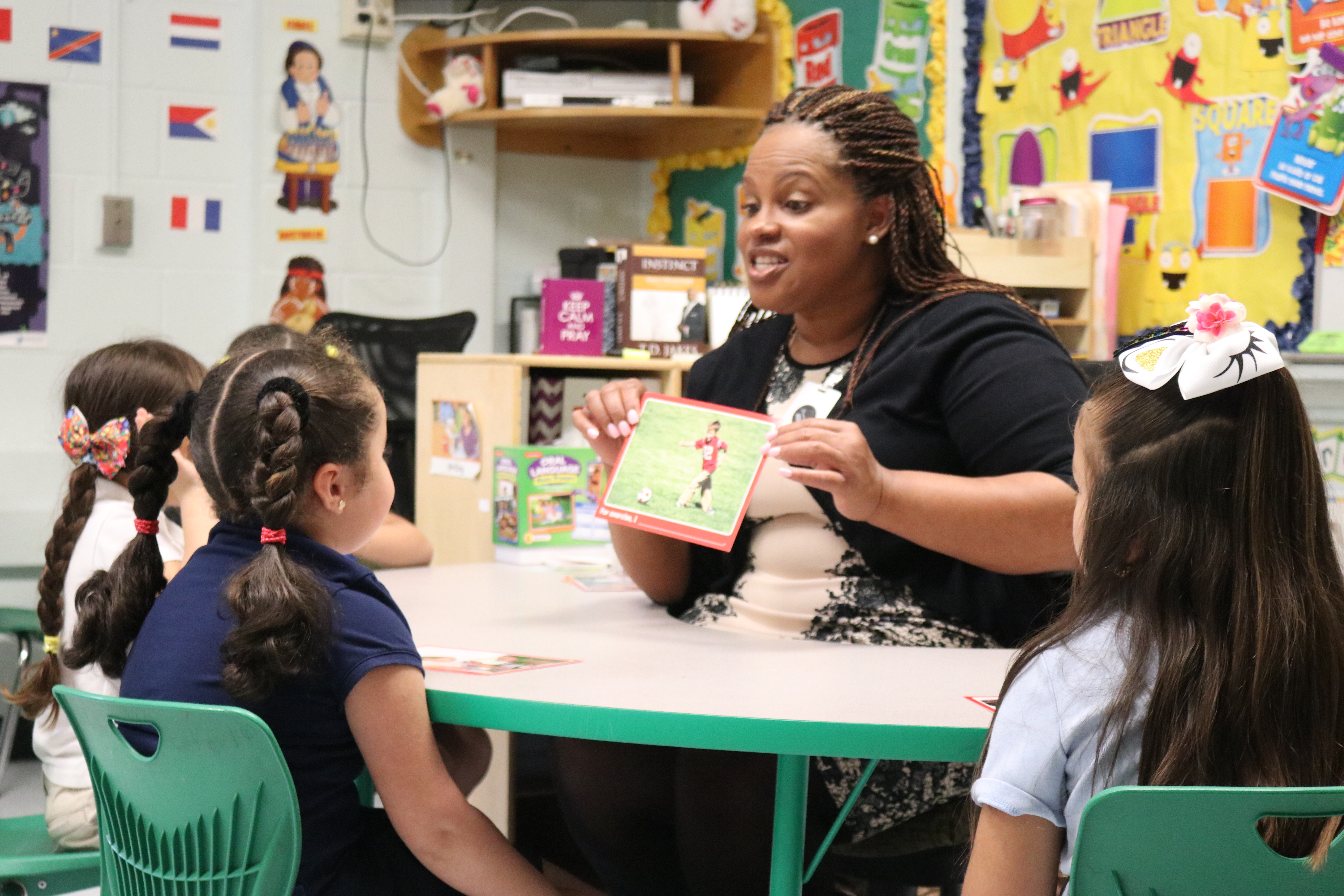 VPK Teacher holds up flashcard with soccer player before students