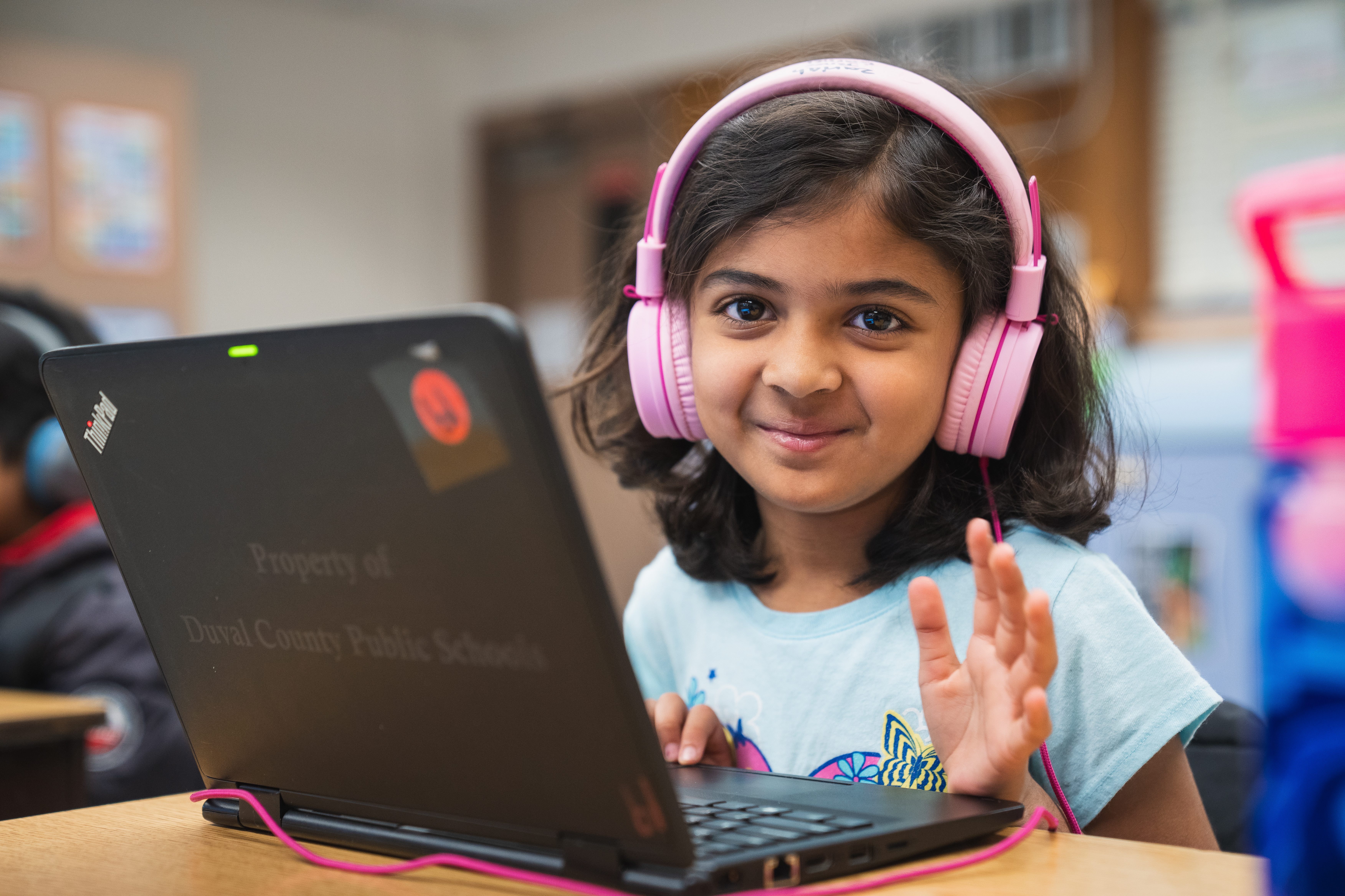 Academics in Duval County. Elementary Student with pink headphones at a laptop