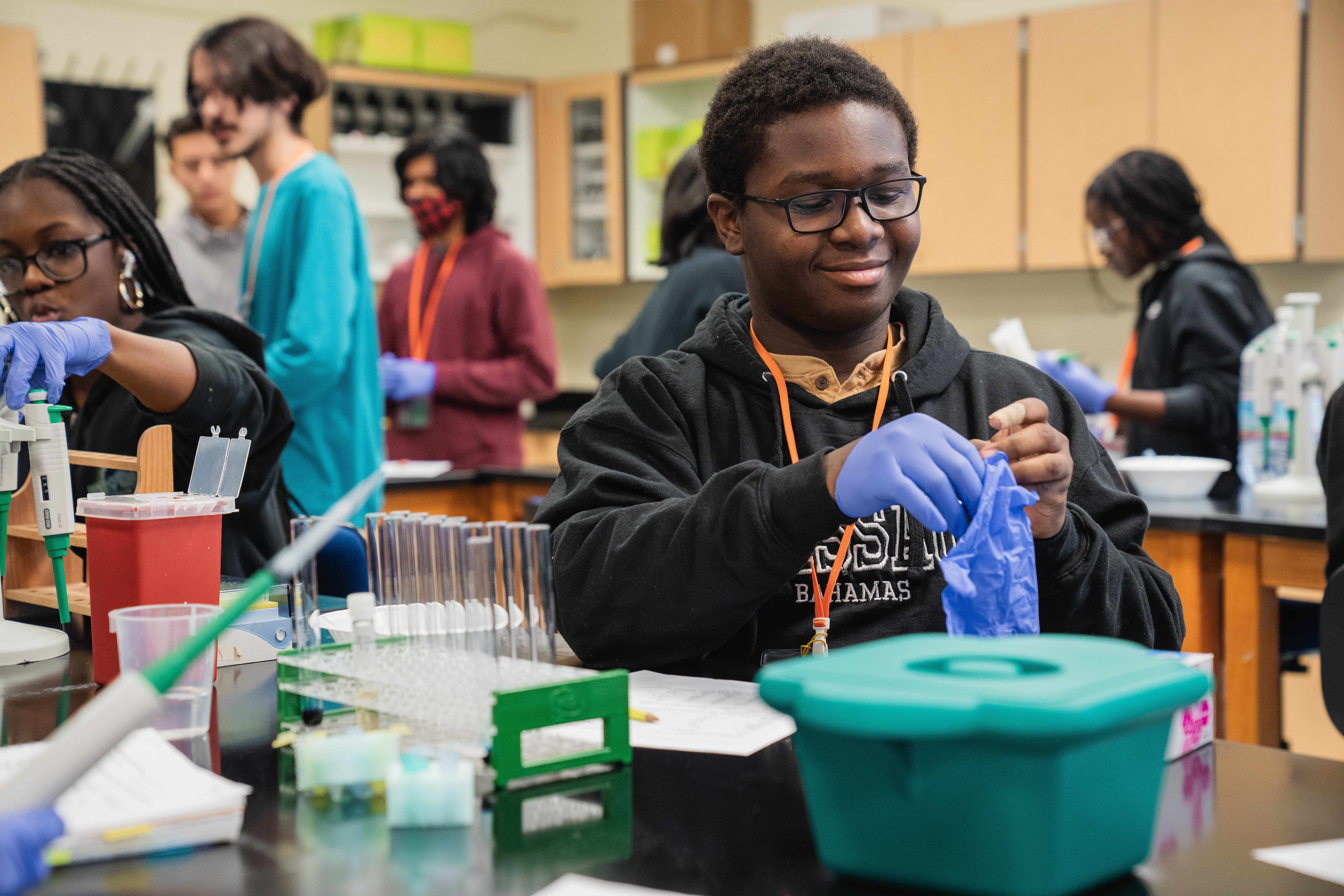 Duval County Public Schools high school student puts on latex gloves in a lab 