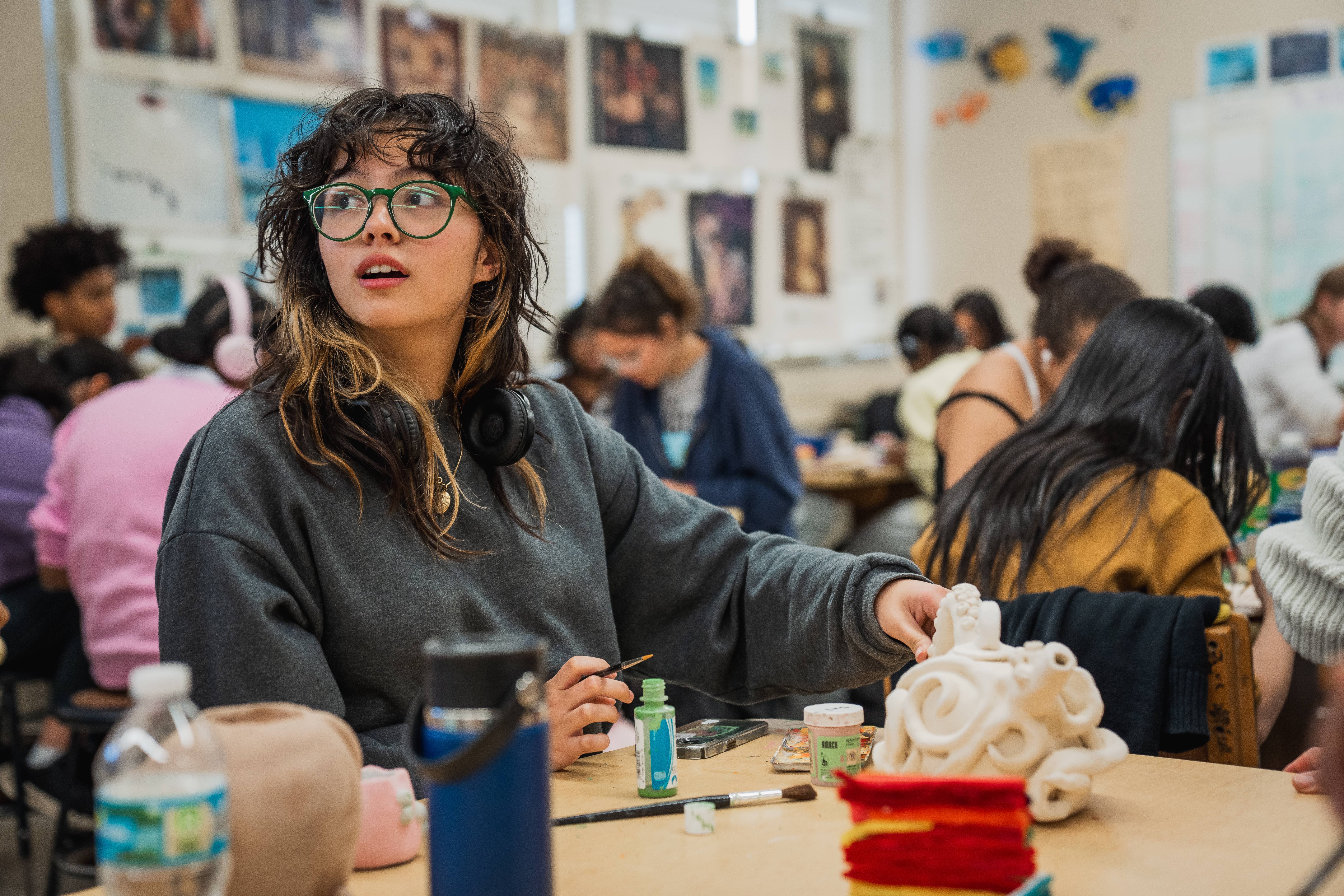 Paxon high school student works on a ceramic piece in art class