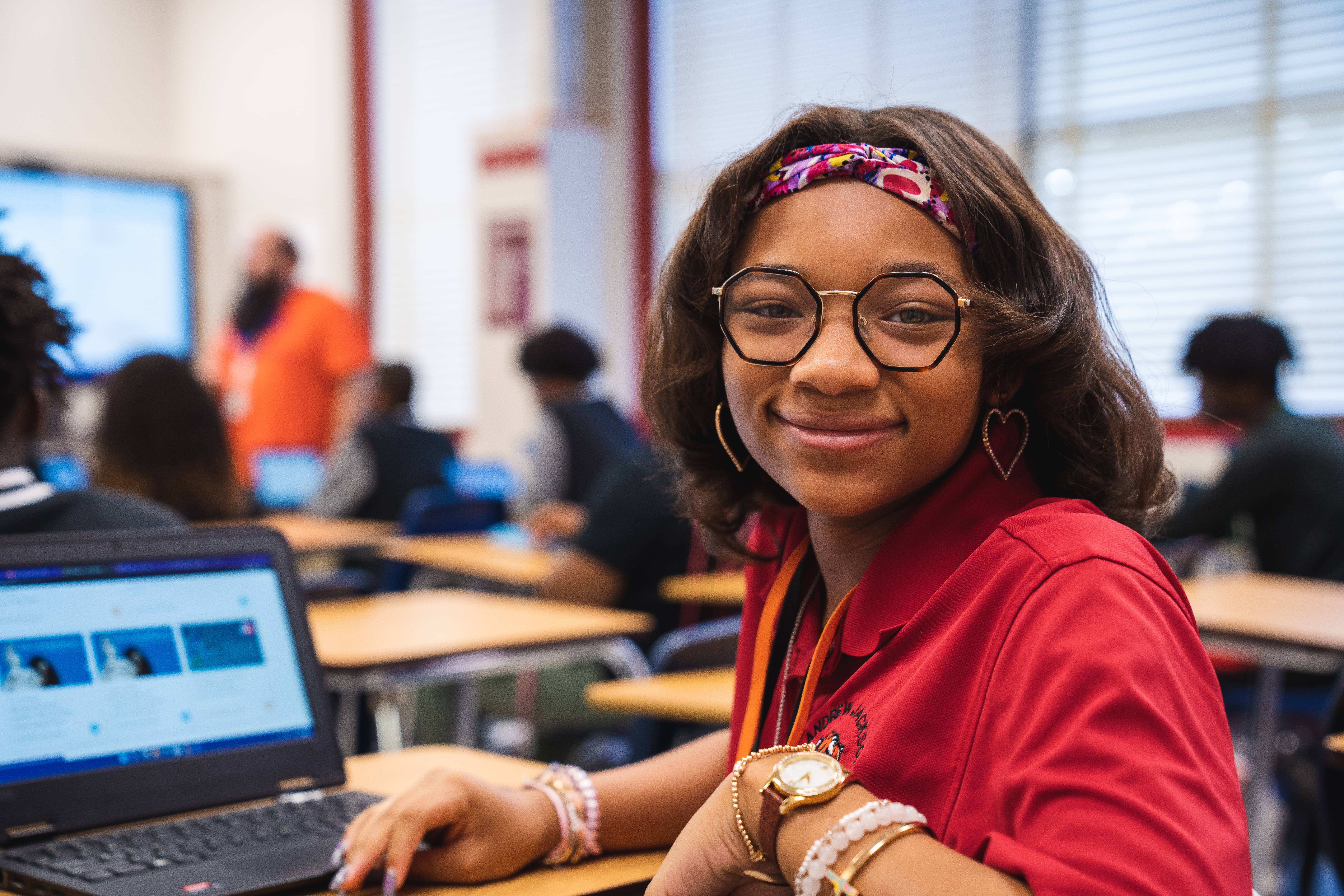 Andrew Jackson High School student sitting and desk and smiling