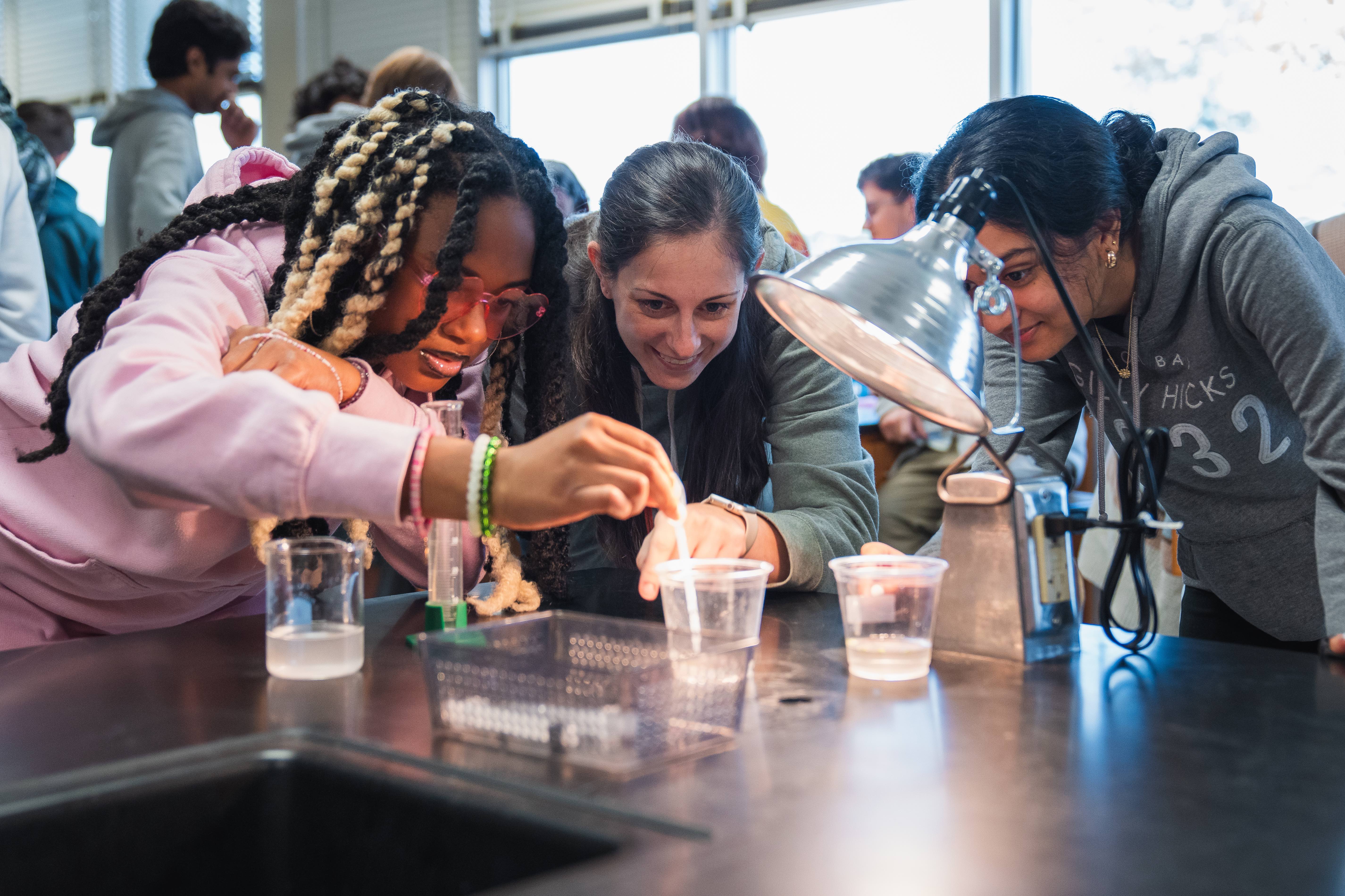 Paxon high school students and teacher using dropper in lab