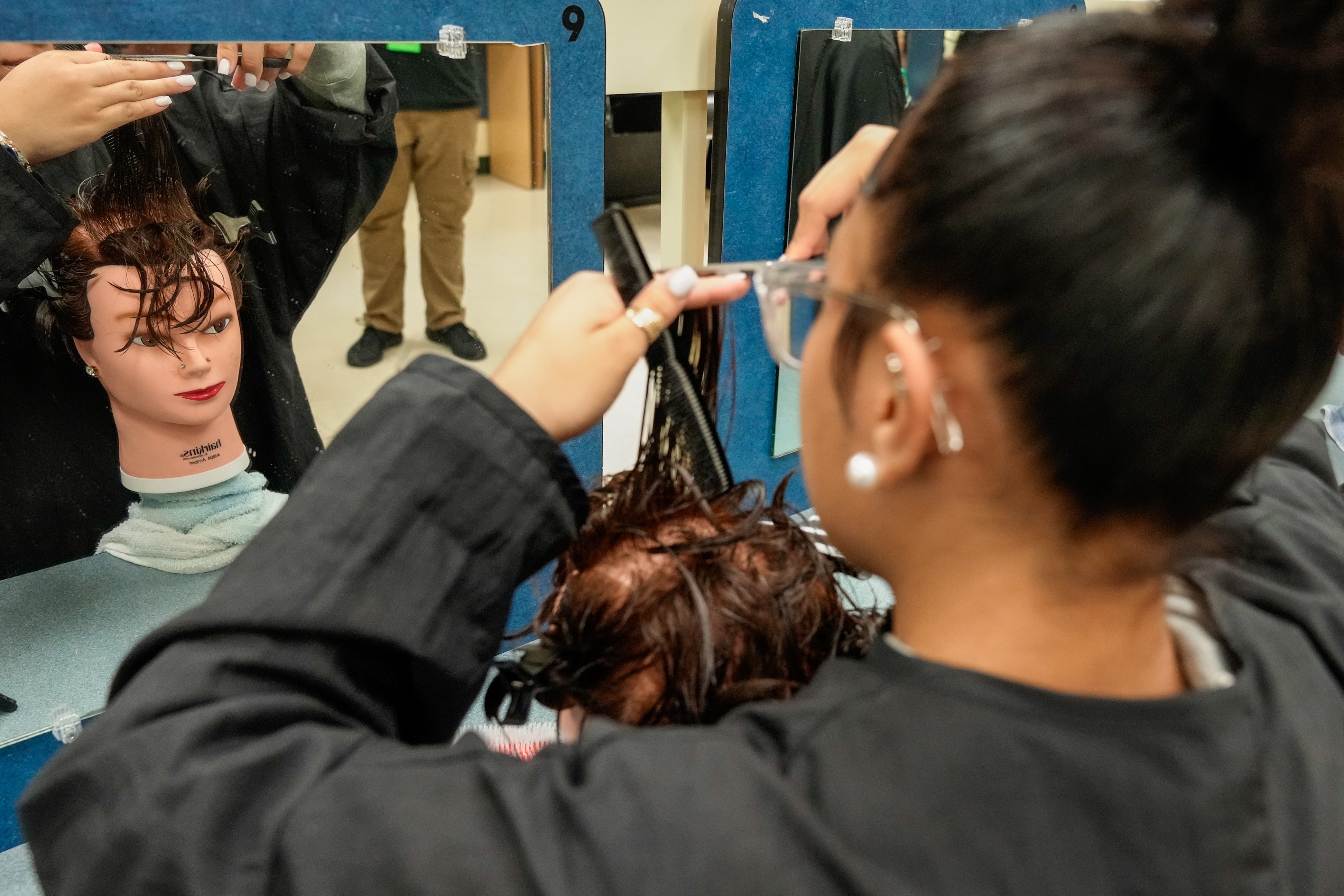 Student working on a mannequin in a Duval County Public Schools cosmetology program