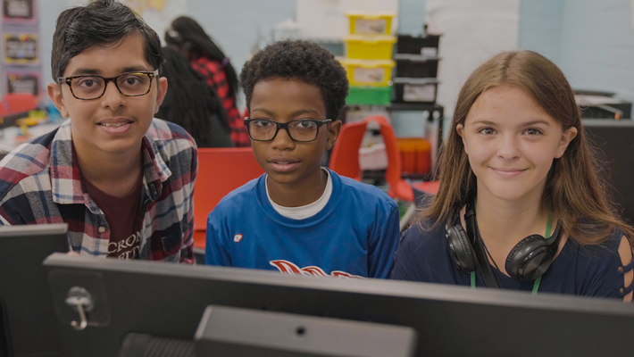 Three Duval Schools middle school students sitting in front of a computer