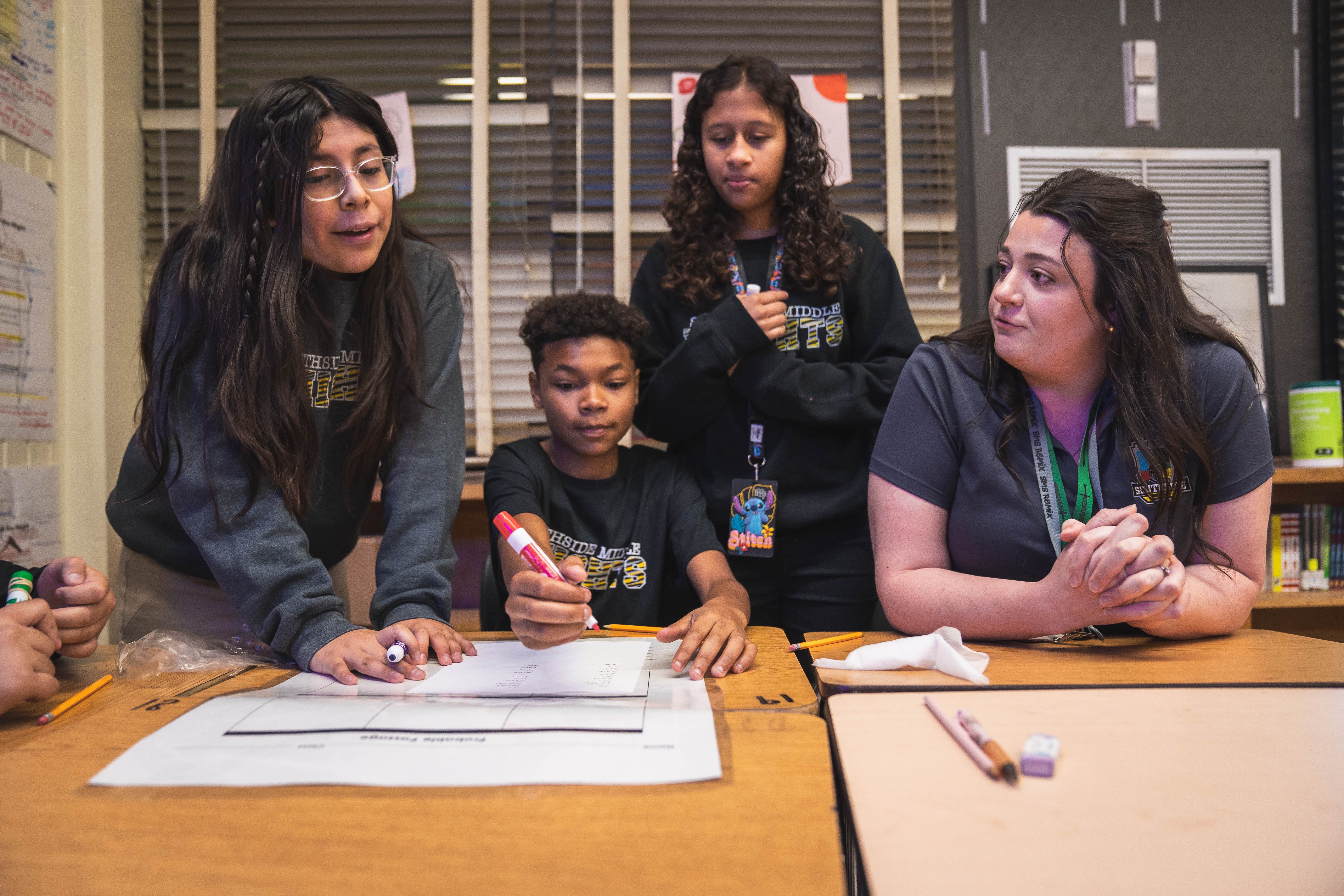 Southside Middle School students working with their teacher at their desks