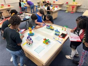 Many students coding in lego lab