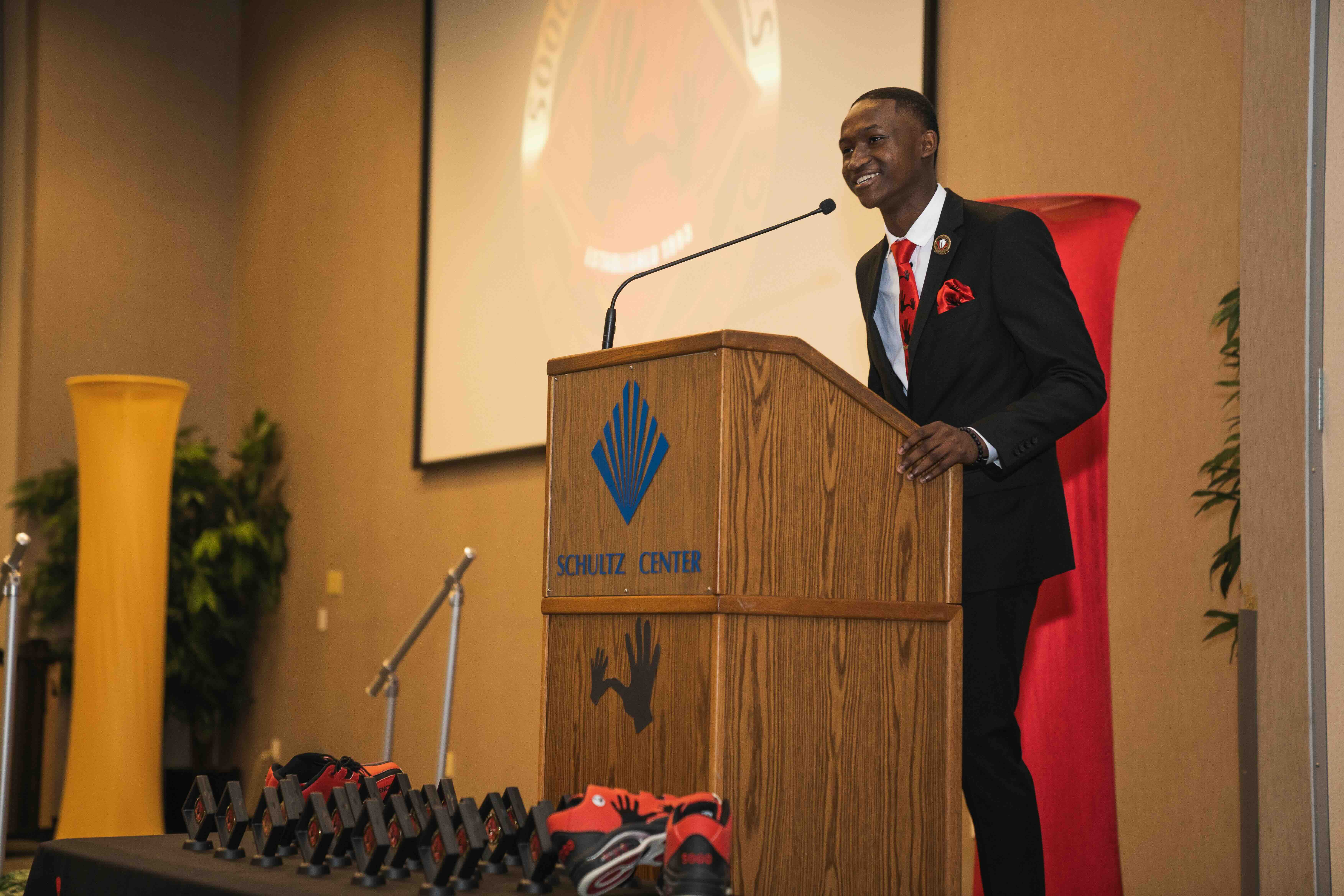 5000 Role Models of Excellence student talking at a podium. 