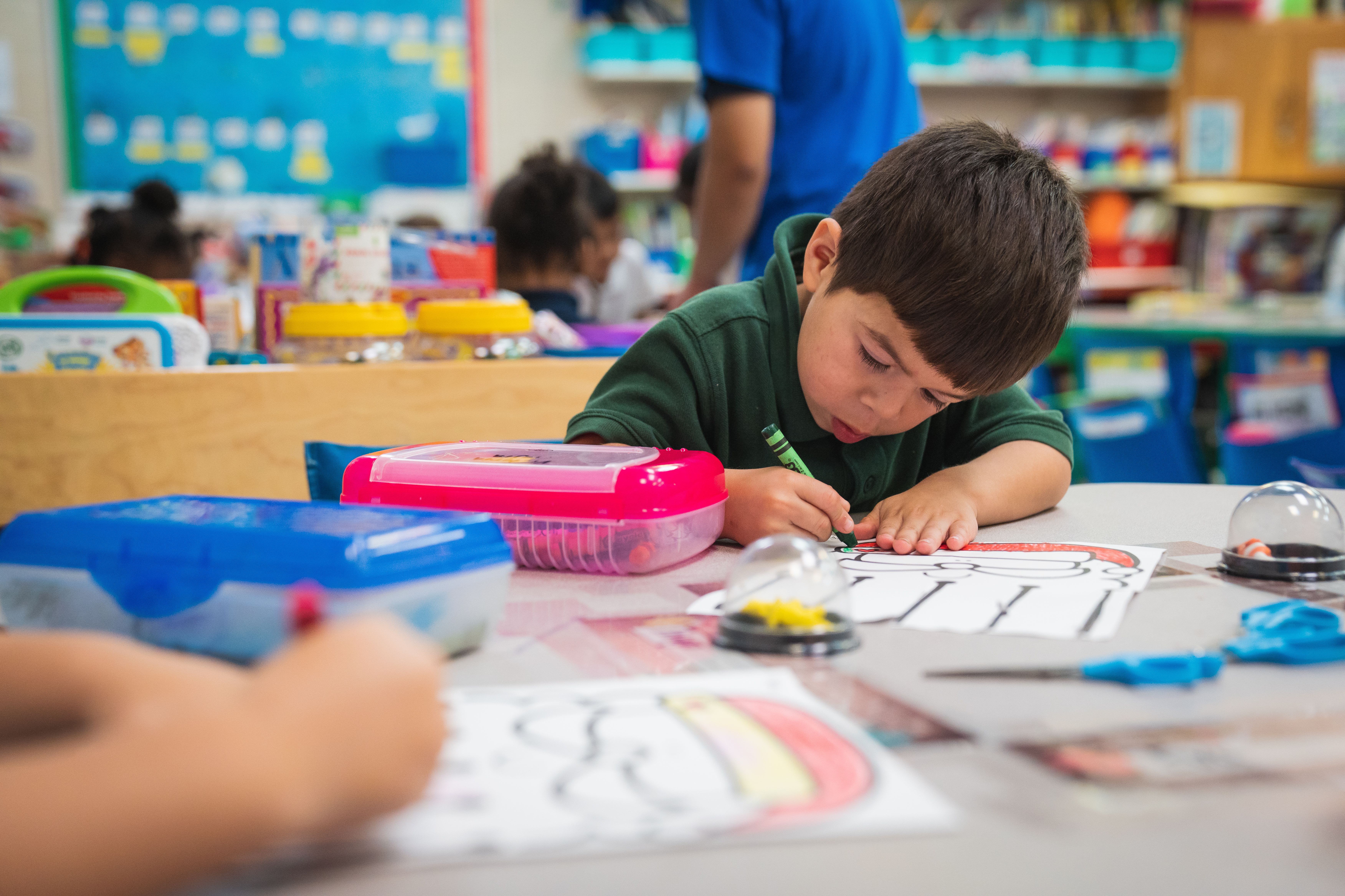 Voluntary Prekindergarten student coloring a sheet in a Duval County class