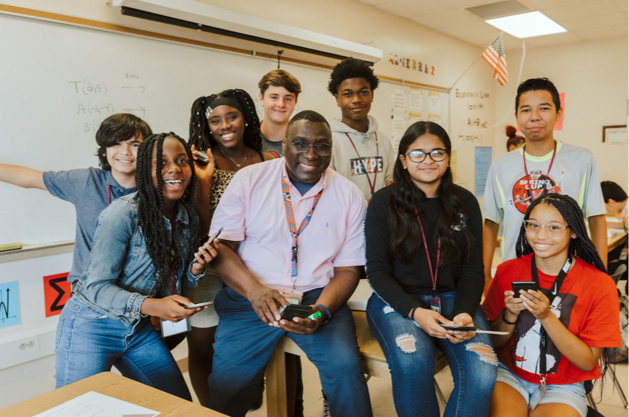 Students and teacher smiling in classroom