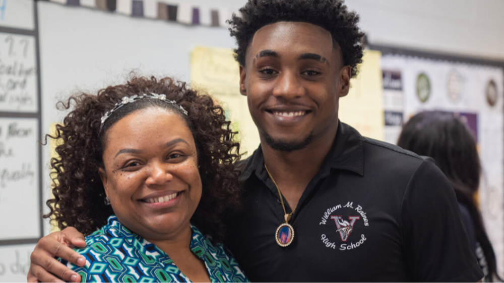 Raines High school Social Studies teacher Jenecy Griffin smiles with a student