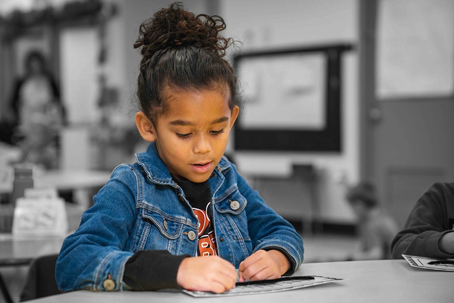 Elementary Student writing in paper