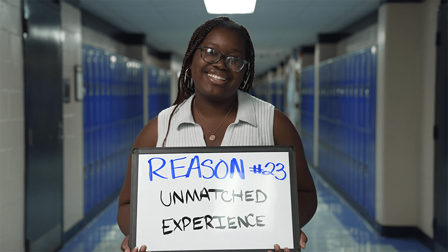 Girl holding a sign that states "Reason #23, Unmatched Experience"