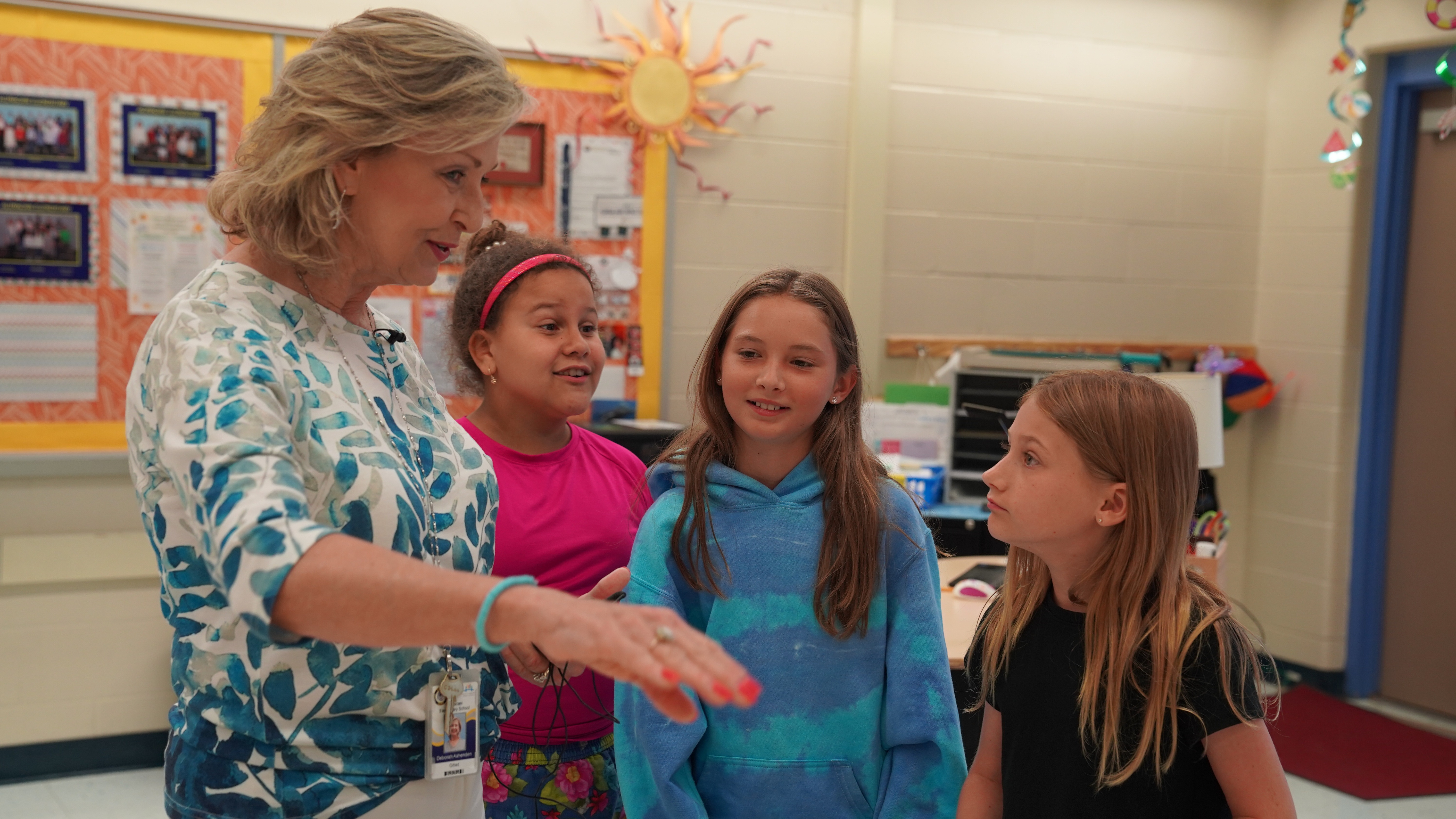 Debbie Ashenden guides students through a classroom activity at Alimacani Elementary, encouraging discussion and hands-on learning.