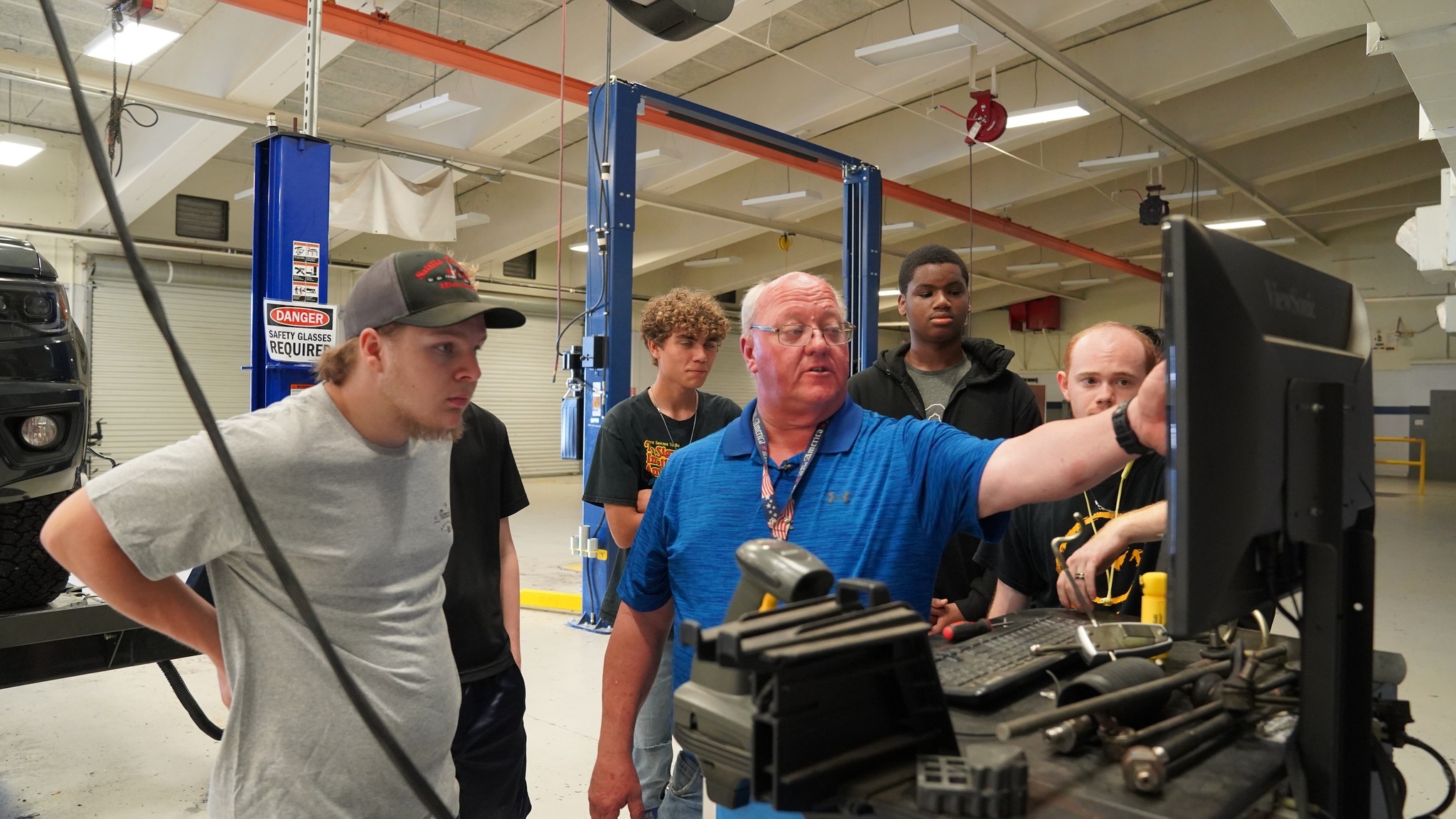 Cory Jeffords teaches an automotive class at Frank H. Peterson Academies of Technology, guiding students as they work on engines and learn real-world technical skills.