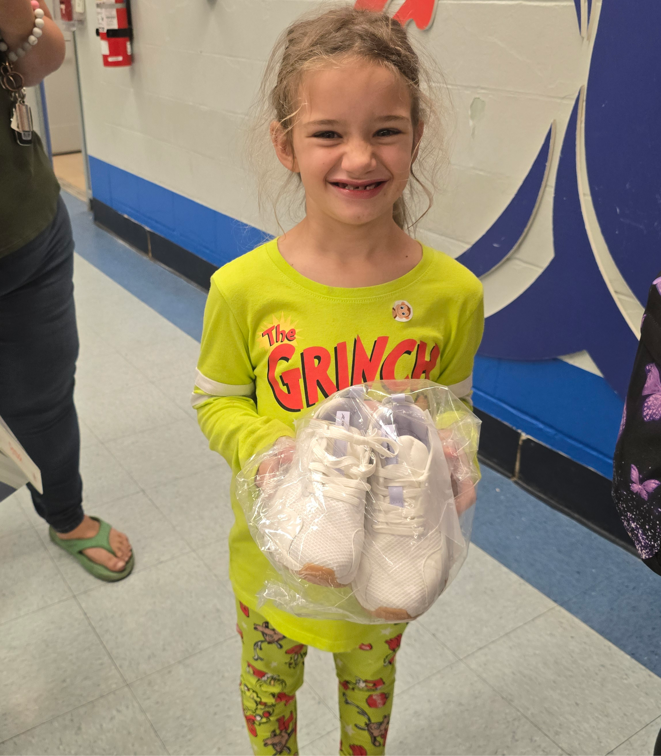 Hidden Oaks Elementary student holds new pair of shoes