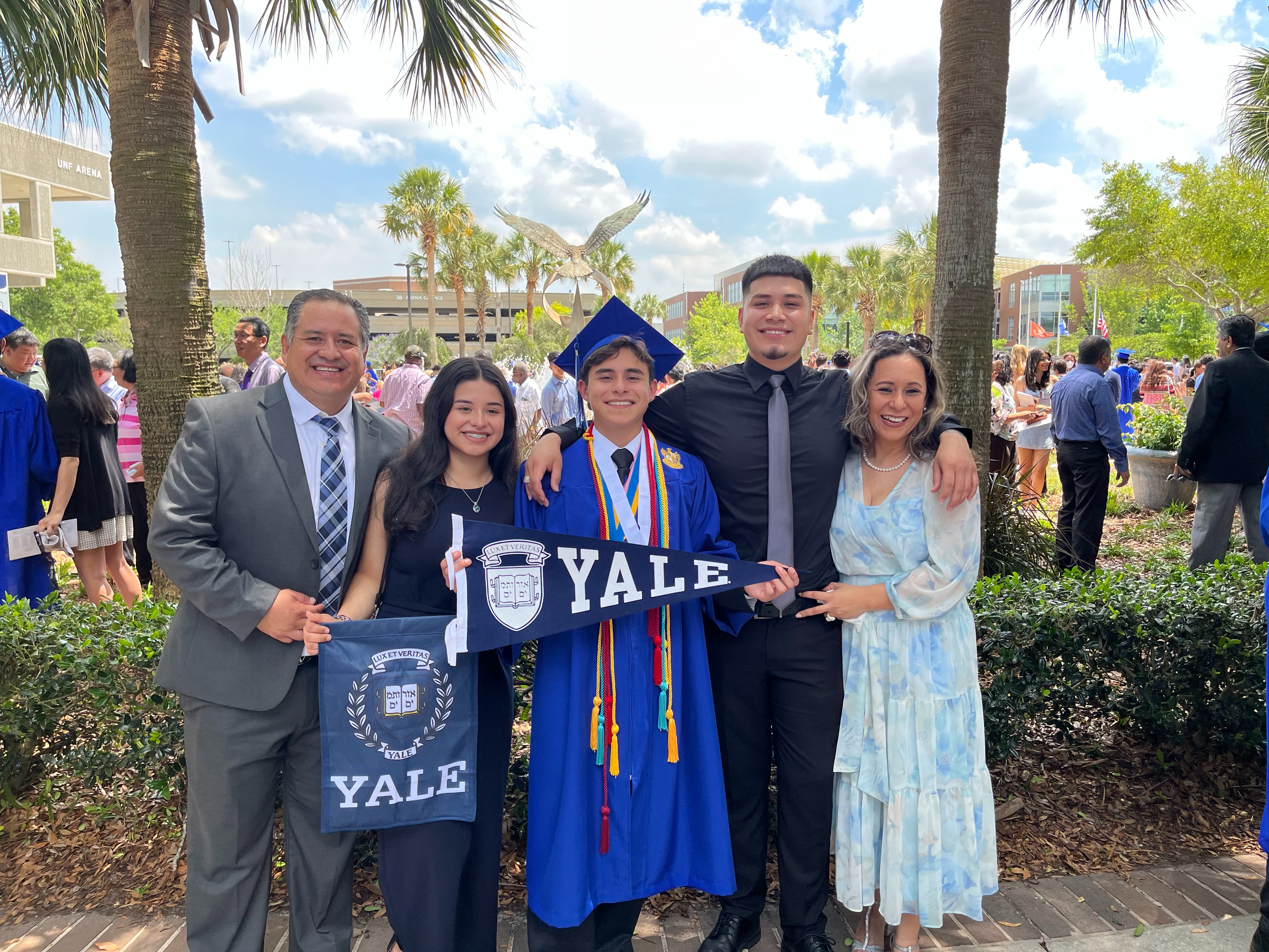 Photo of Alex surrounded by family as they pose for a picture at his Yale graduation ceremony.
